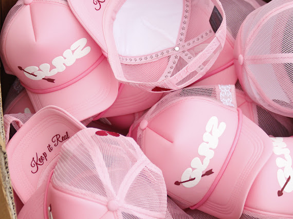 Close-up of a pile of pink GALNEZ trucker caps